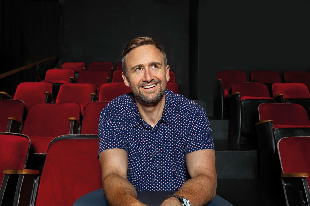 Aortic dissection patient Eli Newell sits in a row of velvet theater seats